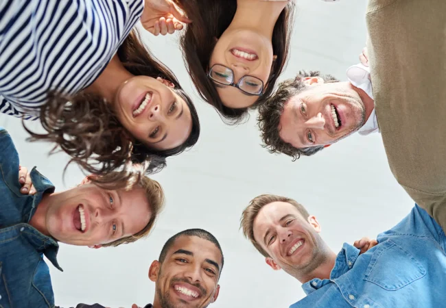 Part of a motivated team. Low angle shot of a team of people smiling down at the camera positively